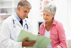 Een vrouw met artritis bij een doktersafspraak